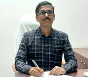 مقامی افسر دفتر میں بیٹھا، قلم کے ساتھ کام کر رہا ہے.