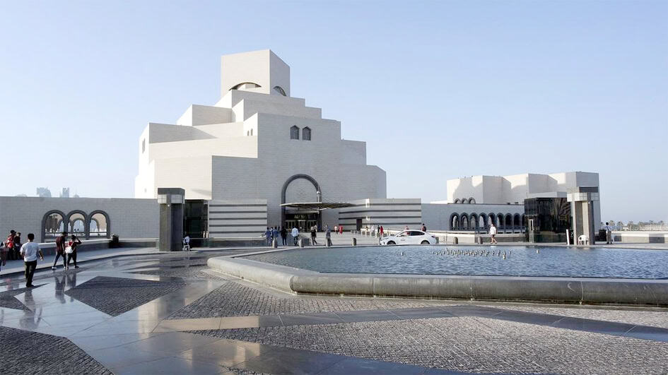 مسجد کا بیرونی منظر، سفید عمارت اور پانی کا فوارہ.