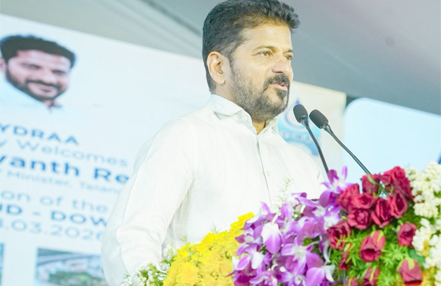 تصویری ALT ٹیگ: مرد تقریر کرتا ہوا، پھولوں کے ساتھ، کانفرنس یا تقریب میں.