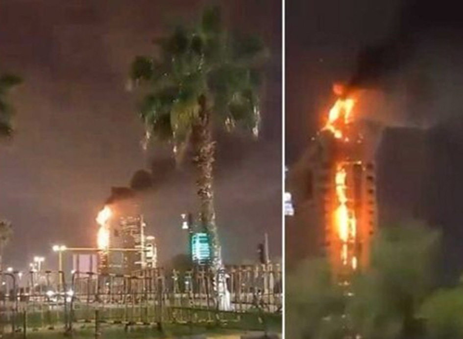 آگ لگتی عمارت کا منظر، بلند شعلے اور دھواں، رات کے وقت شہر میں.