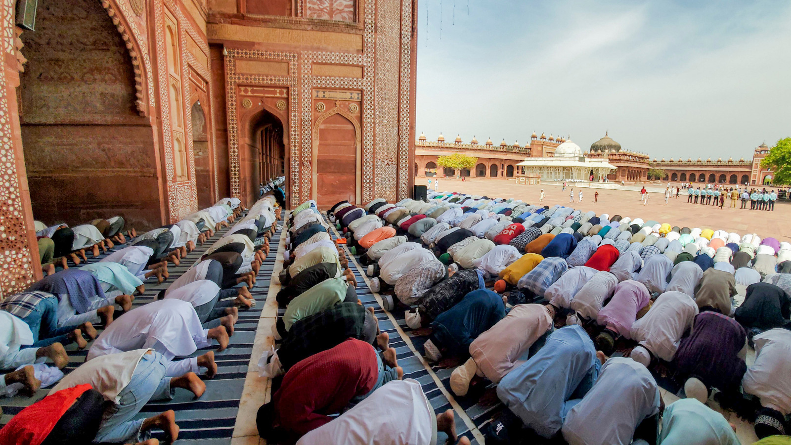 مسلمان افراد کی جماعت نماز پڑھتے ہوئے مسجد کے صحن میں.