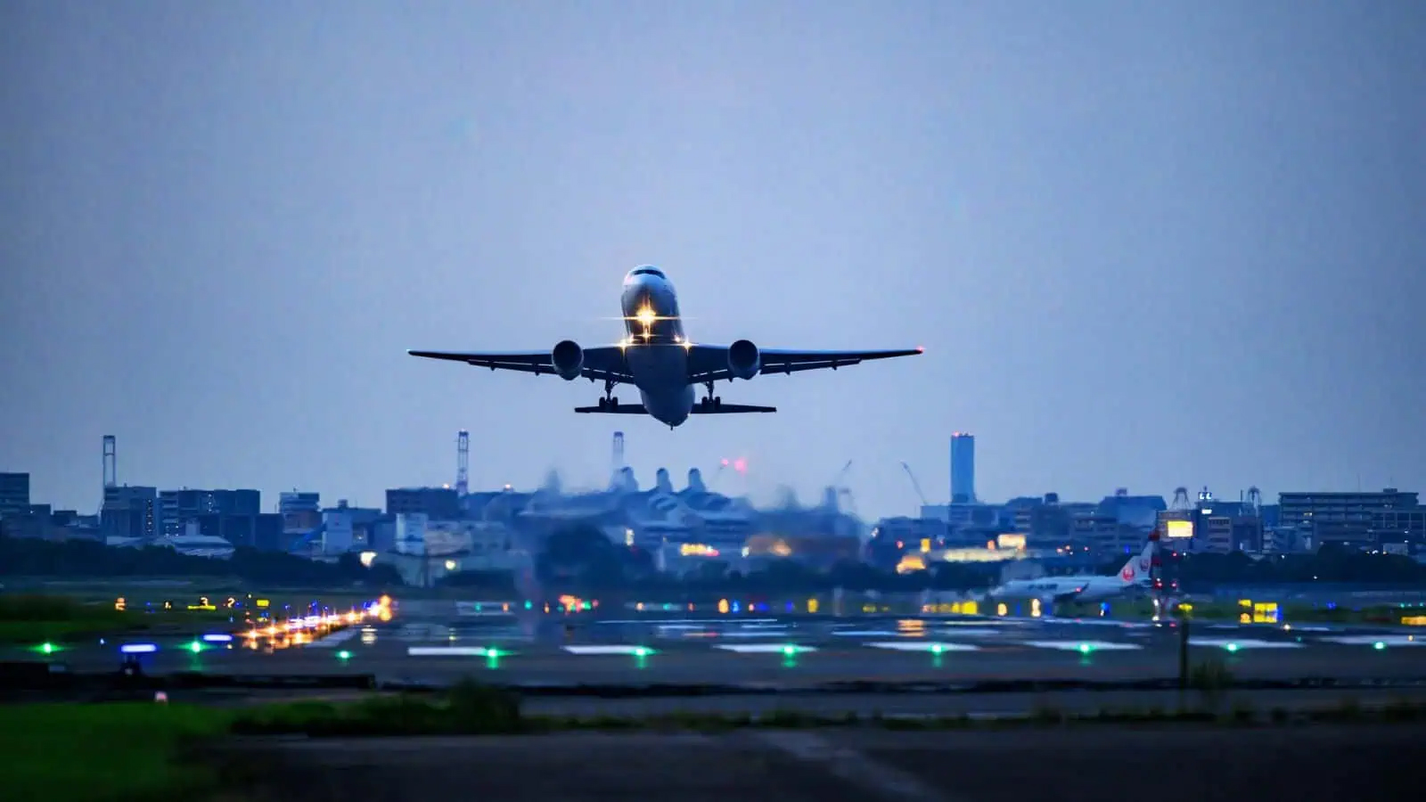 ہوائی جہاز لینڈنگ کے دوران، فضائی اڑان اور شہر کی روشنیوں کے ساتھ۔.