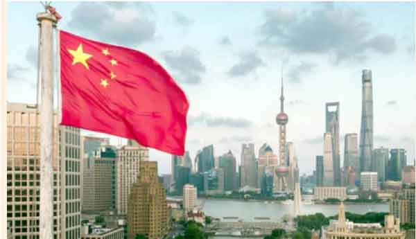 شنگھائی کے شہر میں چینی پرچم لہراتا ہوا، بلند عمارتیں اور آسمان.