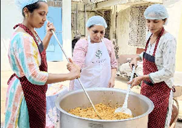 خواتین کھانے کی تیاری کے دوران، بڑے برتن میں کھانا پکاتے ہوئے، سوشل اور کمیونٹی سرگرمی.