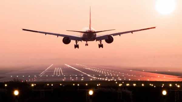 ایئرپورٹ پر لینڈنگ کے لیے تیار ہوائی جہاز، غروب آفتاب کے دوران.