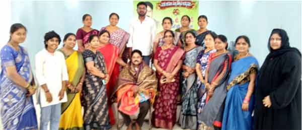 ملازمین کی گروپ تصویر، خواتین اور مرد ملازمین ایک ساتھ کھڑے ہیں، دفتر یا ورکشاپ میں۔.