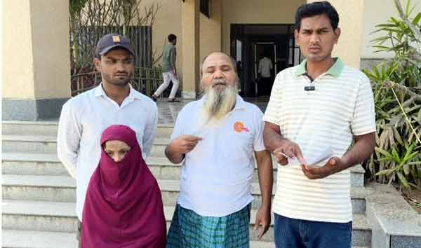 ایمبیڈڈ تصویر میں مرد اور عورت کے گروپ کے افراد، باہر عمارت کے سامنے کھڑے ہیں، ایک شخص ہنسی خوشی بات.