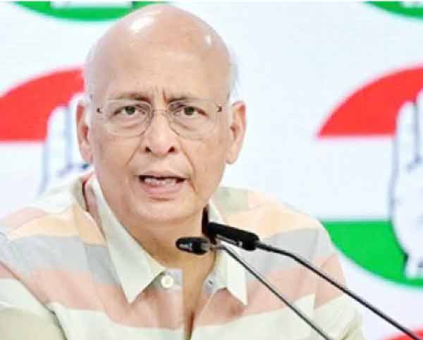 مذکورہ تصویر میں ایک مرد سیاستدان تقریر کر رہا ہے، پس منظر میں بھارتی جھنڈا دکھائی دے رہا ہے۔.