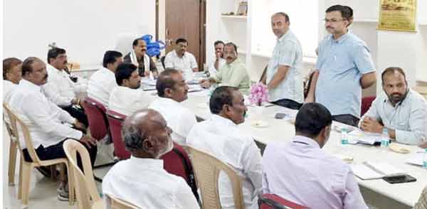 ملاقات میں متعدد افراد بیٹھے ہوئے، ایک شخص گفتگو کر رہا ہے.