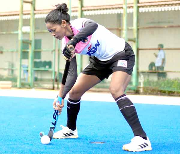 خواتین ہاکی کھلاڑی میدان میں کھیلتی ہوئی، کھیل کے دوران توجہ مرکوز، صحت مند سرگرمی.