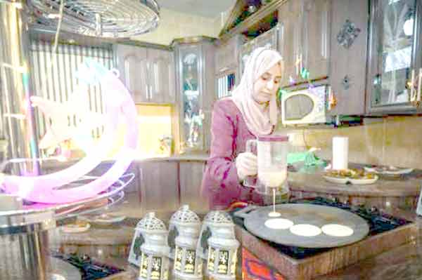 خاتون باورچی خانہ میں پینکیک بنا رہی ہے.