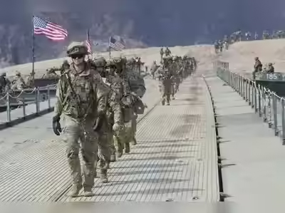 امریکی فوجی فوجی، امریکی پرچم کے ساتھ، ایک پل پر چلتے ہوئے، جنگی حالت میں.