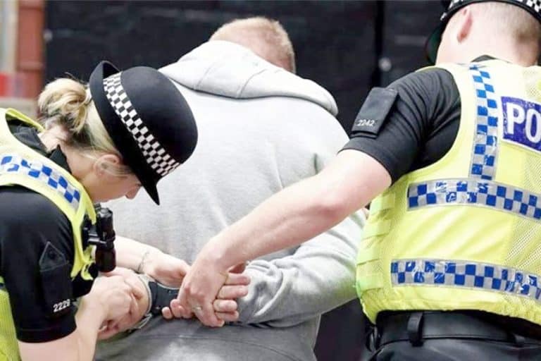 پولیس اہلکار مشتبہ شخص کو حراست میں لیتے ہوئے، حفاظتی اقدامات کے دوران.