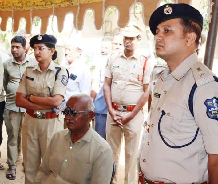 پولیس افسران اور معذور شخص کی ملاقات کی تصویر، حفاظتی لباس میں پولیس اہلکار، عوامی تقریب میں شرکت۔.