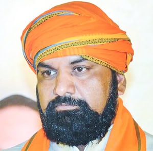 پولیس افسر کا سرخ رنگ کا روایتی ٹوپی پہنے ہوئے، گہرے رنگ کا لباس، سنجیدہ انداز.