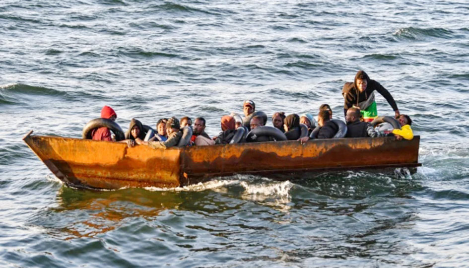 کشتی میں سوار افراد، سمندر میں سفر، انسانی ہجرت کا منظر، تارکین وطن کی مشکلات اور خطرات کی عکاسی.