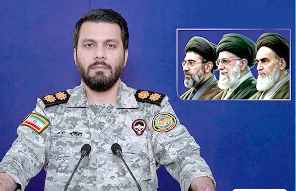 فوجی افسر کی تصویر، جس میں وہ پریس کانفرنس کے دوران بات کر رہے ہیں، پس منظر میں دیگر فوجی رہنما بھی.