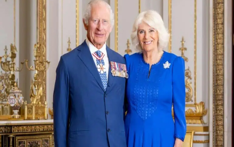 ملکی جوڑے، شاہی لباس میں، ایک خوبصورت کمرے میں، مسکراہٹ کے ساتھ.