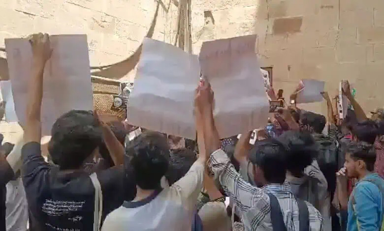 احتجاجی مظاہرہ میں نوجوان ہاتھ میں کاغذات اٹھائے، مظاہرین کا احتجاجی مظاہرہ.