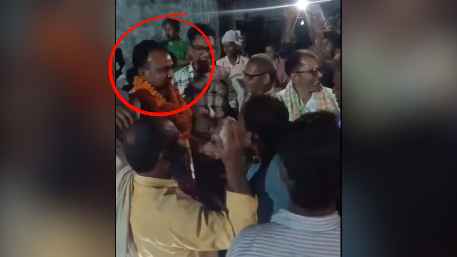 ہجوم میں ایک شخص کی تصویر، جو تقریب میں موجود ہے، اور دیگر افراد کے ساتھ مصروف گفتگو کر رہا ہے.