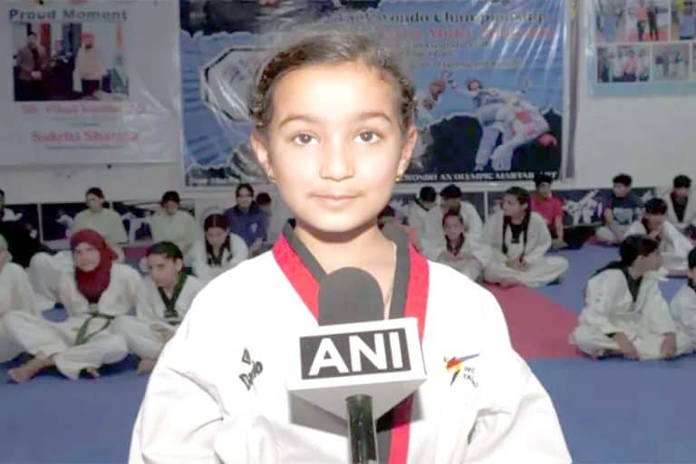 کودک جودو مقابلہ میں انعام حاصل کرتی ہوئی، سیاہ بیلٹ کے ساتھ، انٹرویو دیتے ہوئے.