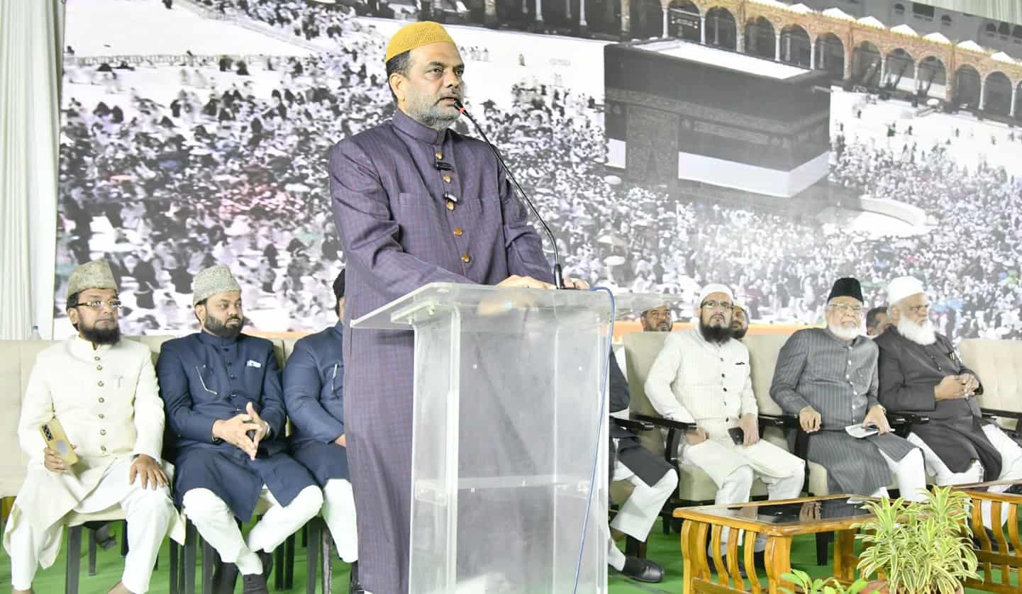 مذہبی تقریب میں ایک شخص تقریر کر رہا ہے، دیگر افراد بھی موجود ہیں.