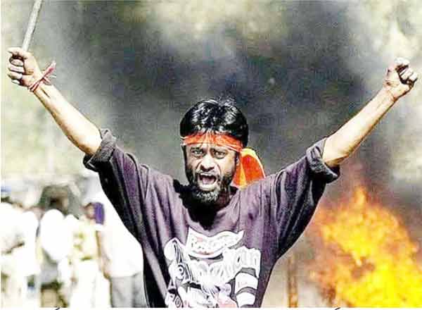 مظاہرہ کرنے والا شخص احتجاج کے دوران غصہ اور جذبات کا اظہار کر رہا ہے، پس منظر میں دھواں اور آگ، سیا.