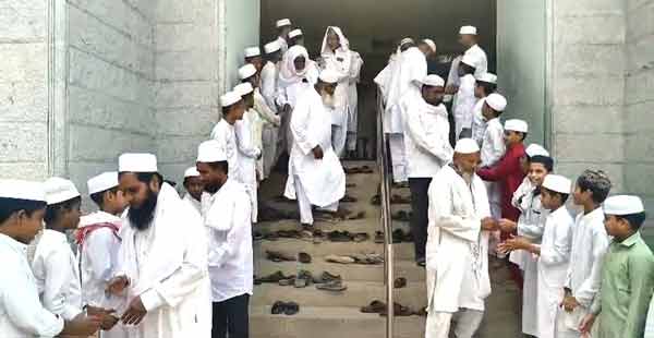 نماز پڑھتے ہوئے مسلمان افراد کی گروپ تصویر.