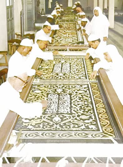مذہبی تقریب کے لیے ہاتھ سے بنے قالین کی تیاری، مسلمان خواتین اور مرد قالین کے کنارے اور وسط میں کام.