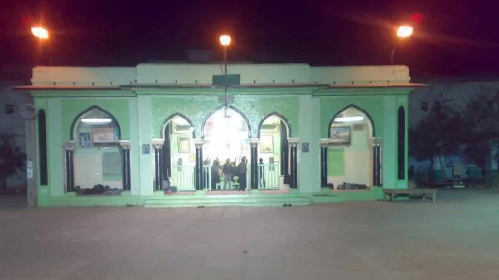 مسجد کا بیرونی منظر، روشنیاں اور دروازہ، رات کے وقت.