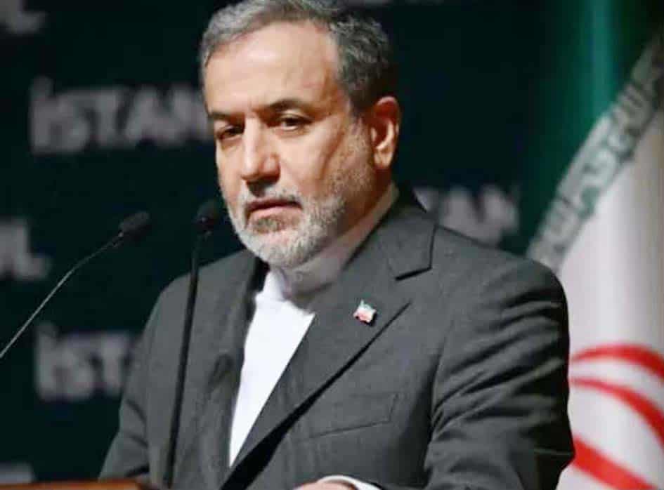 ایرانی سیاستدان کی تقریر کی تصویر، جس میں وہ رسمی لباس میں کھڑے ہیں، پس منظر میں ایرانی جھنڈا اور سی.
