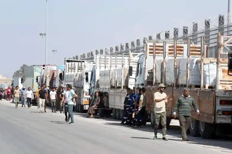 ٹرکوں کی قطار میں لوگ اور مسافر.