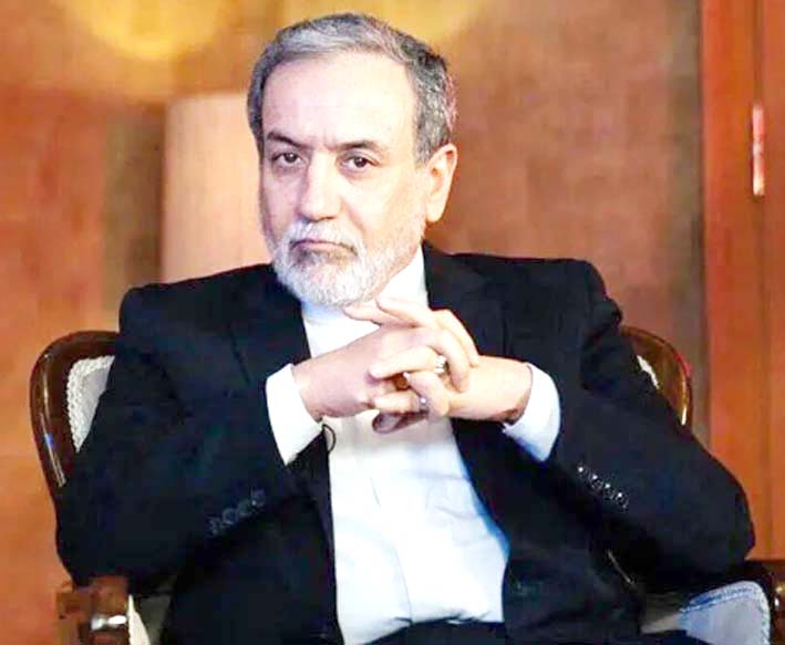 ایک شخص کی تصویر، رسمی لباس میں، بیٹھا ہوا، سنجیدہ اندا.
