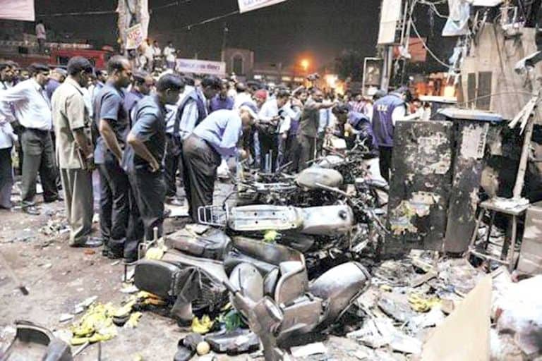 حادثہ کے مقام پر لوگ اور پولیس جمع، تباہ شدہ موٹر سائیکلیں اور نقصان شدہ اشیاء.