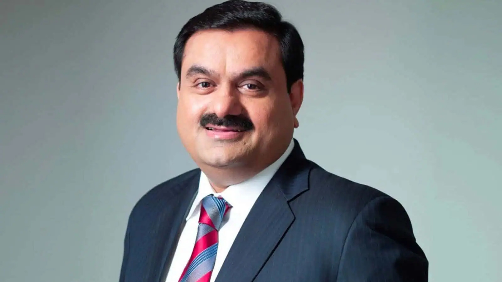پاکستانی سیاستدان کا سرکاری لباس میں مسکراتا ہوا چہرہ.