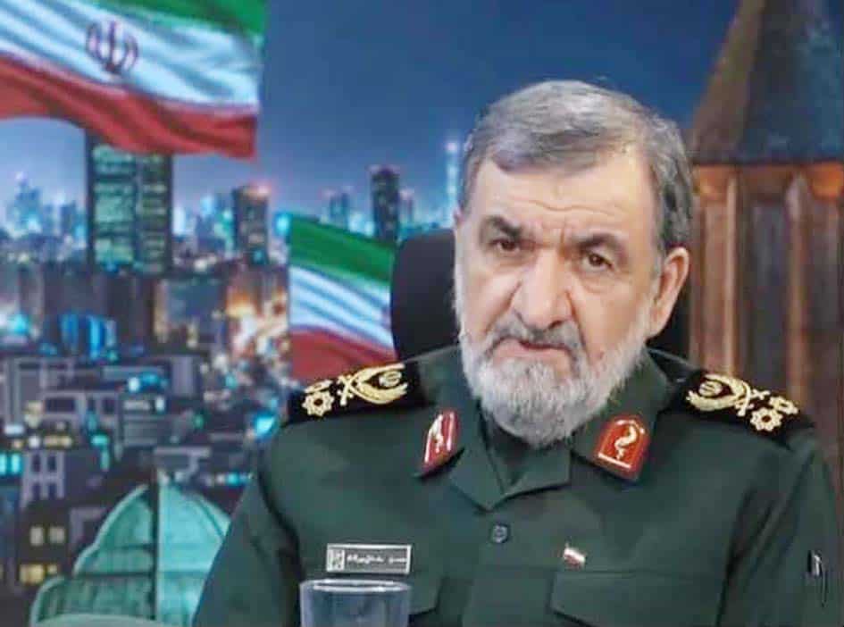 ایرانی فوجی افسر، فوجی یونیفارم میں، پس منظر میں شہر کی روشنیوں کے ساتھ.