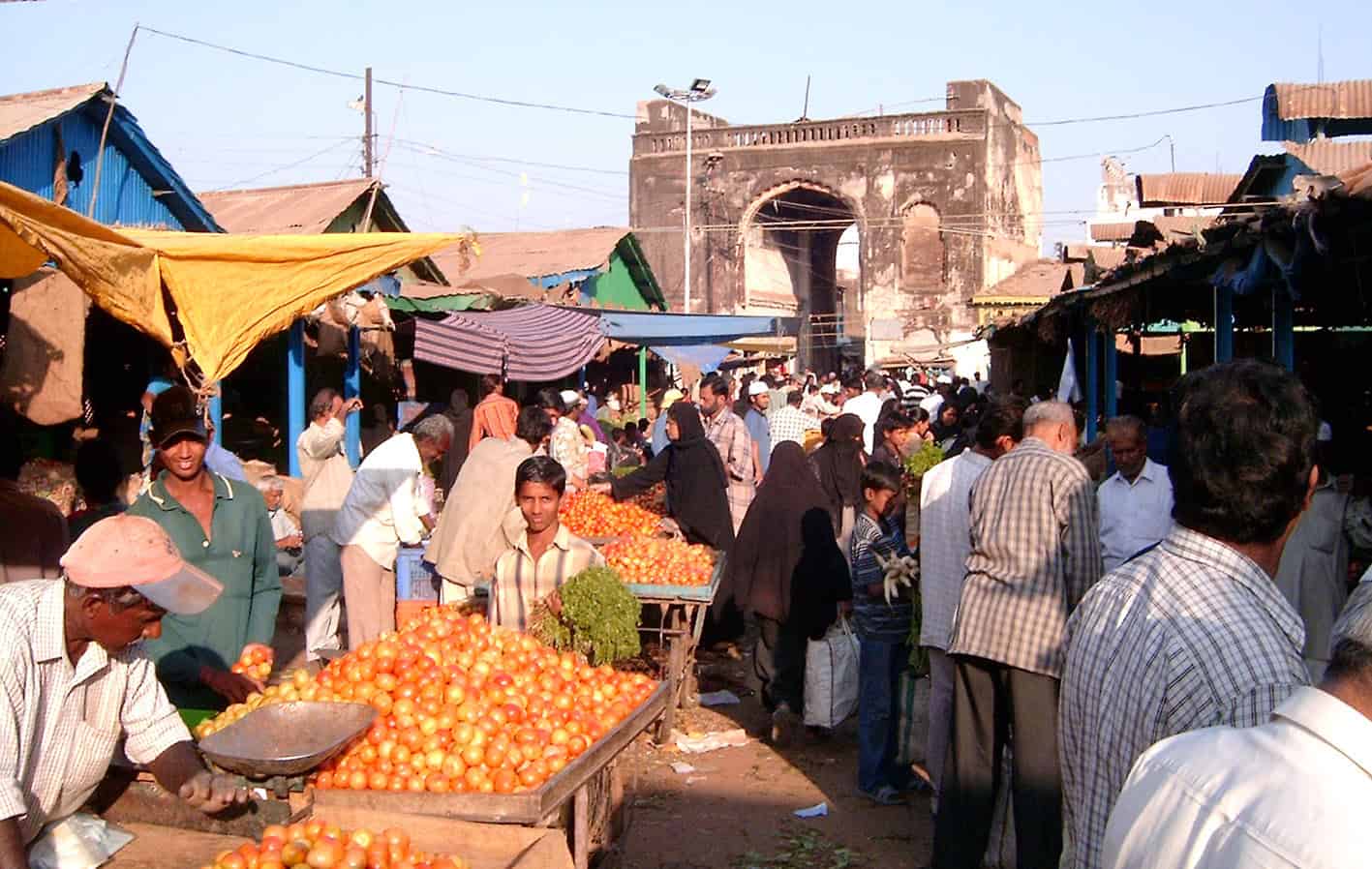 ہجوم اور سبزیاں بیچنے والے، تاریخی دروازہ پس منظر میں.