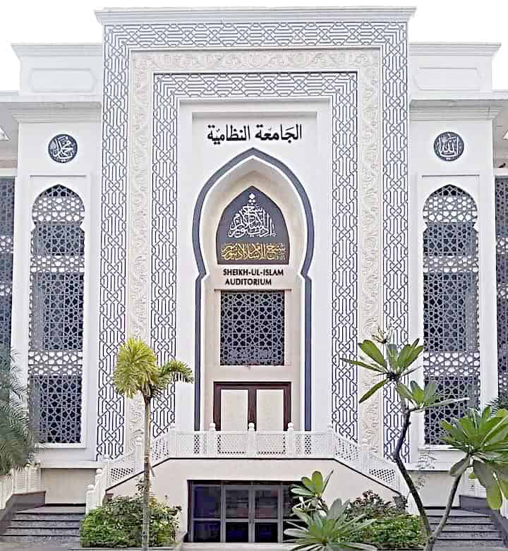 شیخ الاسلام آڈیٹوریم کا بیرونی منظر، خوبصورت اسلامی فن تعمیر کے ساتھ سفید عمارت.