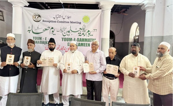 مختلف افراد ملاقات میں کتابیں اور اسناد لے کر کھڑے ہیں.
