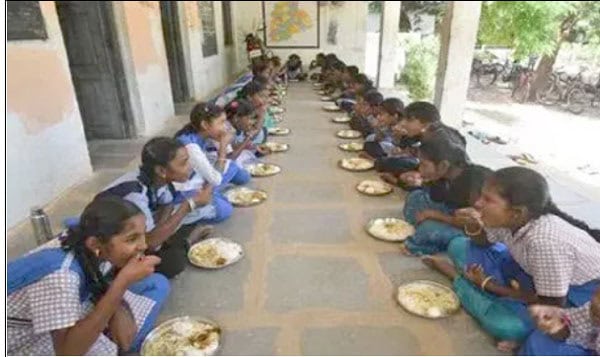 طالبات ایک لمبے ٹیبل پر بیٹھ کر کھانا کھا رہی ہیں.