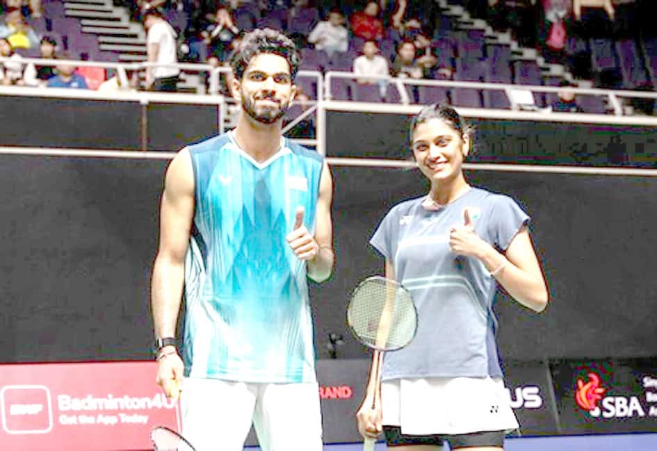 Badminton کے کھلاڑیوں کی خوشگوار تصویر، ایک مرد اور ایک عورت، کھیل کے میدان میں.