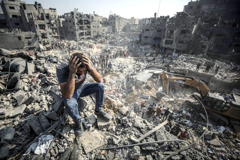 تباہ شدہ عمارتوں کے بیچ میں غمگین فلسطینی شخص.