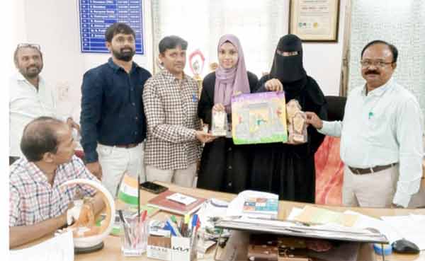 خاتون کو تحفہ دیتے ہوئے خواتین و حضرات کی گروپ تصویر.
