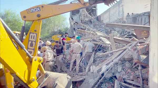 تباہ شدہ عمارت کے ملبے میں امدادی کارکن اور مشینری.