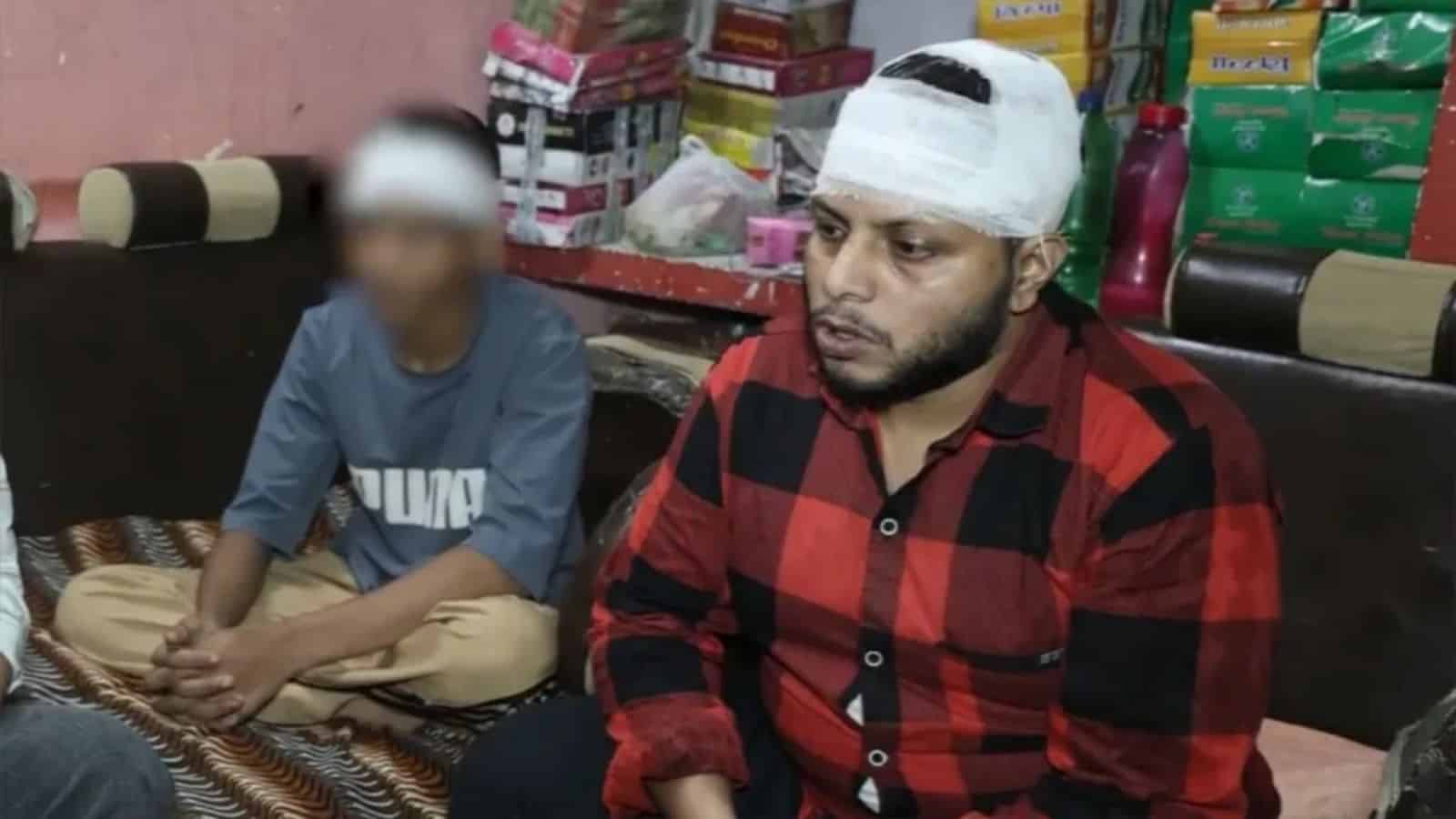 زخمی شخص کے سر پر پٹی بندھی ہوئی ہے، طبی امداد دی جا رہی ہے.