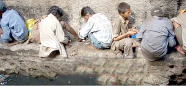 پانی کے کنارے بچے بیٹھے ہوئے، تعلیم اور تفریح کا منظر.
